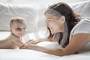 Happy loving family. mother playing with her baby in the bedroom.