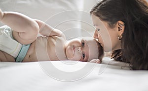 Happy loving family. mother playing with her baby in the bedroom.