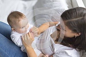 Happy loving family. mother playing with her baby in the bedroom.