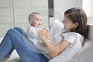 Happy loving family. mother playing with her baby in the bedroom.