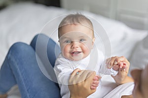 Happy loving family. mother playing with her baby in the bedroom. Close up on the baby