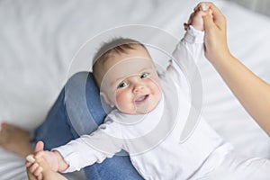 Happy loving family. mother playing with her baby in the bedroom. Close up on the baby