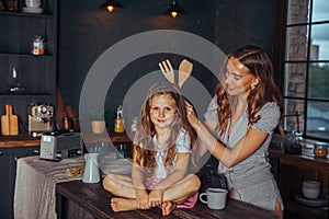 Happy loving family preparing dinner together. Smiling Mom and child daughter girl cooking and having fun in the kitchen. Homemade