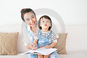 Happy loving family. Pretty young asian mother reading a book to