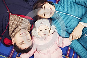 Happy loving family(mother, father and little daughter kid) outdoors walking having fun on a park in autumn season. Fallen yellow