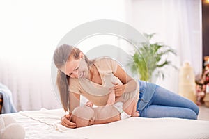 Happy loving family. A young mother plays with her child in the bedroom