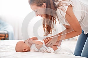 Happy loving family. A young mother plays with her child in the bedroom