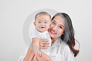 Happy loving family. Young smiling mother hugging laughing baby.