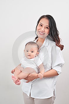 Happy loving family. Young smiling mother hugging laughing baby.