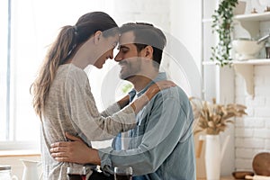 Happy loving mixed race couple enjoying sweet moment in kitchen.