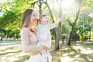 Happy loving mother and her baby having fun outdoors in the park