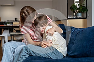 Happy loving mother hugging child son while having fun together at home