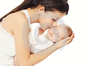 Happy loving mother kissing her baby holding on hands over white