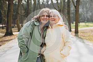 Happy loving older mature mother and daughter laughing embracing, caring young woman embracing senior middle aged mom