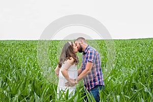 Happy loving young adult couple spending time on the field on sunny day