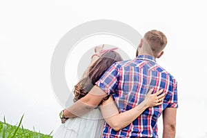 Happy loving young adult couple spending time on the field on sunny day