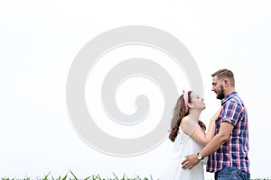Happy loving young adult couple spending time on the field on sunny day