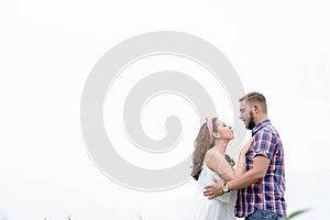 Happy loving young adult couple spending time on the field on sunny day