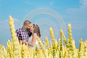 Happy loving young adult couple spending time on the field on sunny day.