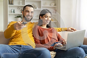 Happy loving young couple spending time together on couch at home