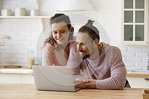 Happy loving young couple using computer at home.