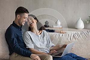 Happy loving young family couple using computer at home.