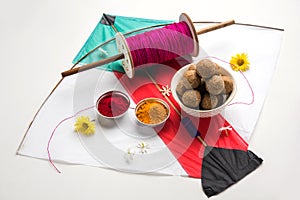 Happy Makar Sankranti Festival - Tilgul or Til ladoo in a bowl or plate with haldi kumkum and flowers with Fikri /Reel/Chakri /Spo