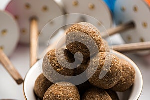 Happy Makar Sankranti Festival - Tilgul or Til ladoo in a bowl or plate with haldi kumkum and flowers with Fikri /Reel/Chakri /Spo