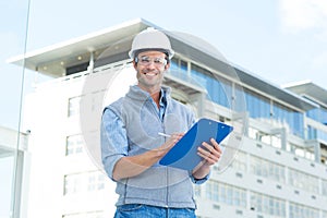 Happy male architect writing on clipboard