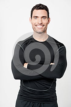 Happy male athlete with folded arms