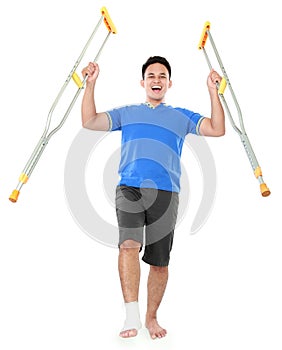 Happy male with broken foot using crutch
