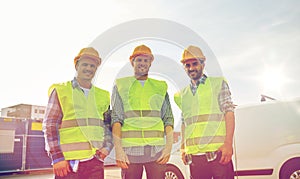 Happy male builders in high visible vests outdoors