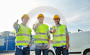 Happy male builders in high visible vests outdoors photo