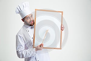 Happy male chef cook holding blank board