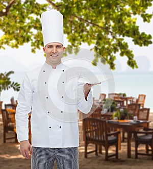 Happy male chef cook showing empty plate