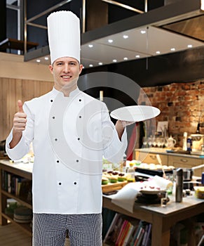 Happy male chef cook showing thumbs up and plate