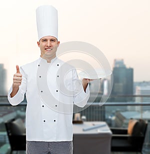 Happy male chef cook showing thumbs up and plate