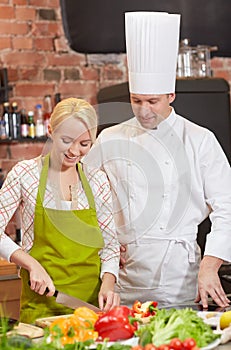 Happy male chef cook with woman cooking in kitchen