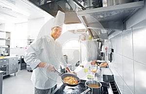 Happy male chef cooking food at restaurant kitchen