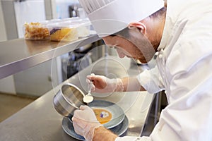 Happy male chef cooking food at restaurant kitchen