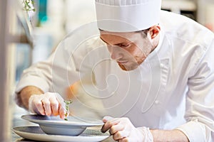 Happy male chef cooking food at restaurant kitchen