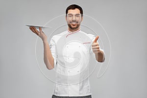 happy male chef with empty plate showing thumbs up