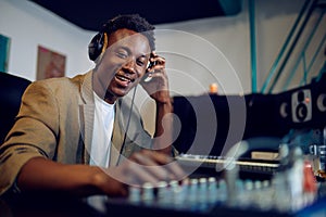 Happy male dj in headphones, recording studio photo