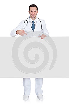 Happy male doctor holding empty placard