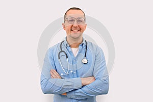 Happy male doctor looking at camera on light background. Health care and medicine