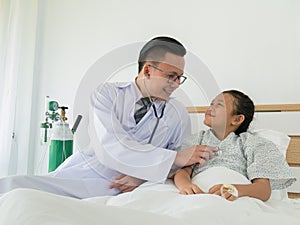 A happy male doctor uses a stethoscope to check the patient`s bo