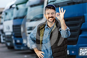 Happy male driver standing in front of his truck