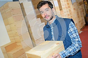 Happy male employee holding wine bottles box at manufactory