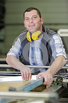 happy male engineer working on machine in factory