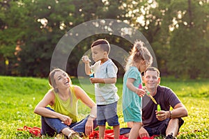 Happy male and female playing with children outside